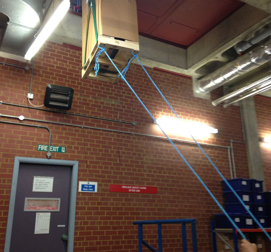 UPS (uninterruptible power supply) being hoisted up and through a small opening during installation by Enhanced Power Services Ltd.